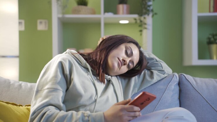 Sleepy and exhausted woman looking at phone. Sleep time.