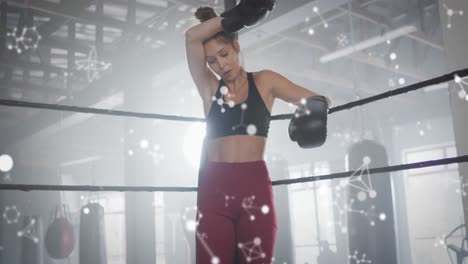 animación de moléculas y procesamiento de datos sobre mujer caucásica haciendo ejercicio en el gimnasio de boxeo