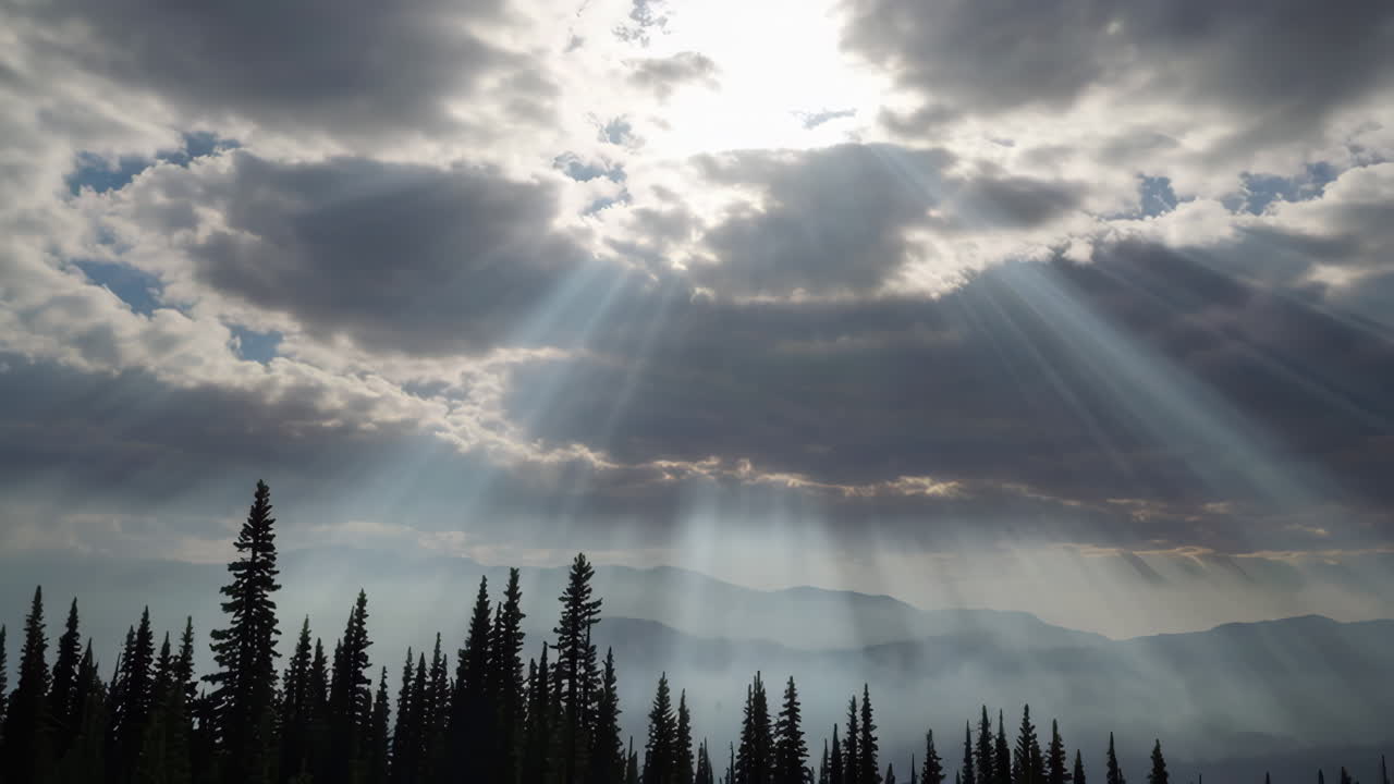 Raios de Sol Dramáticos Atravessando Nuvens Sobre uma Floresta Silhuetada e Montanhas Nevoentas