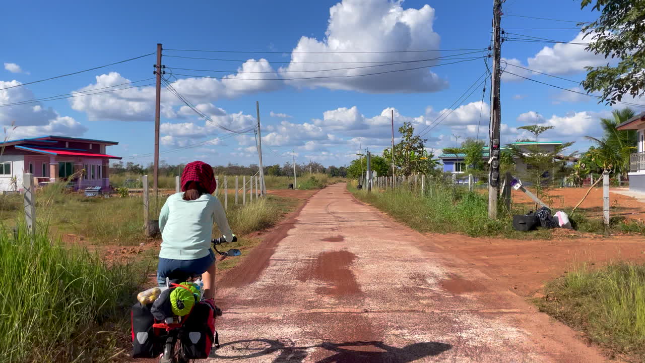 뒷좌석에 패니어와 식료품을 싣고 자전거를 타고 출퇴근하는 여성의 다이내믹한 영상