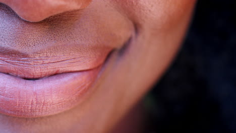 un lado de la boca de una mujer negra sonriente, detalle
