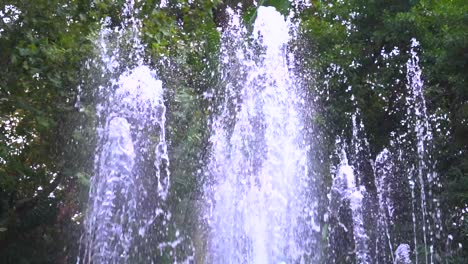 Cierre-La-Fuente-De-Agua-En-Cámara-Lenta-Contra-Los-árboles-Verdes-Y-La-Naturaleza,-Rodada-En-Marbella,-Málaga,-España-A-120-Fps