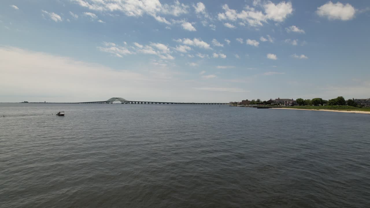 아름다운 아침에 풀이 무성한 해안에서 시작하는 그레이트 사우스 베이 다리의 낮은 각도