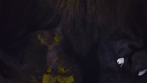 aerial view over natural textures and patterns of the icelandic highlands dark mountain terrain, covered in green grass
