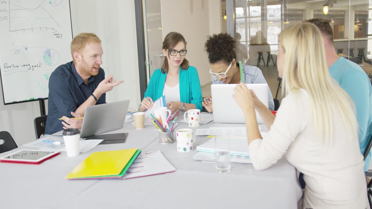 Jovens colegas de trabalho analisando um gráfico no escritório