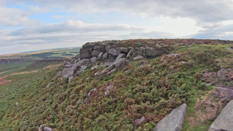 quick flying aerial fpv soars along gritstone rocky cliffs of stanage edge england