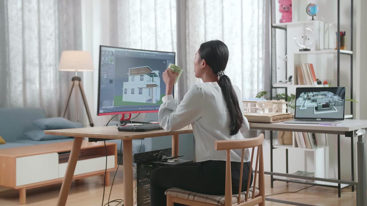 Asian Woman Engineer Drinking Coffee While Designing House On A Desktop At Home. Cyber Games House Design And Decoration