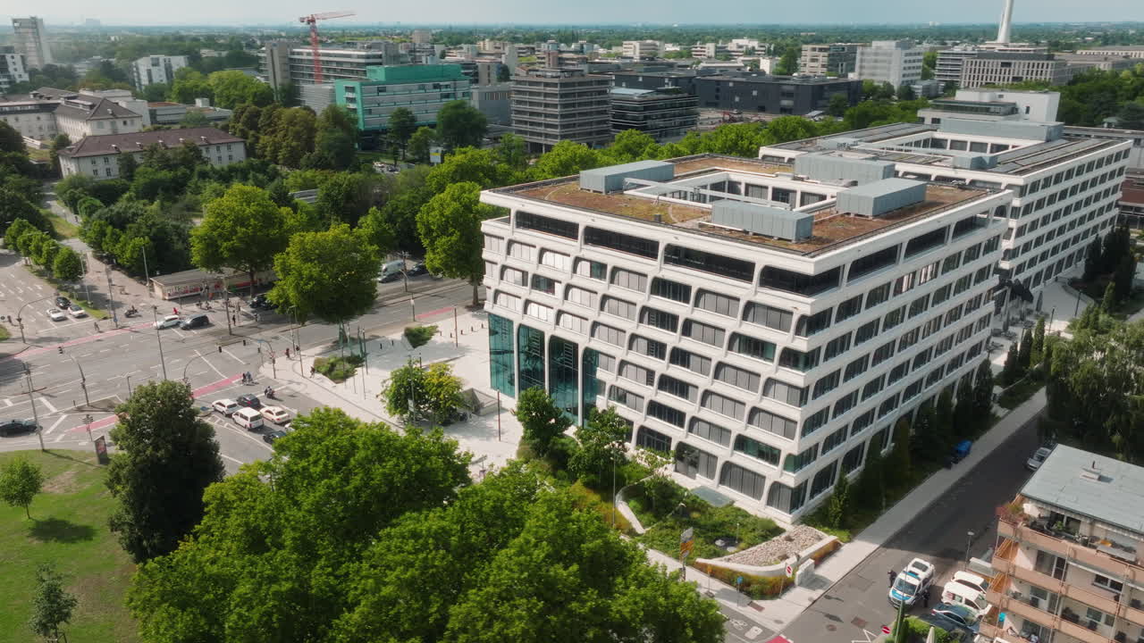 Orbiting drone shot around the European Patent Office with park, streets and modern district