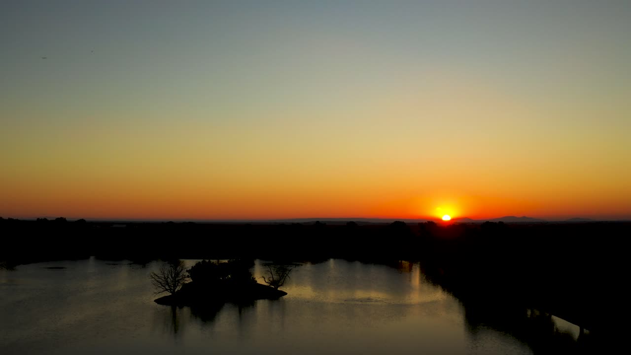 Auringonnousu järven yllä aavikolla.