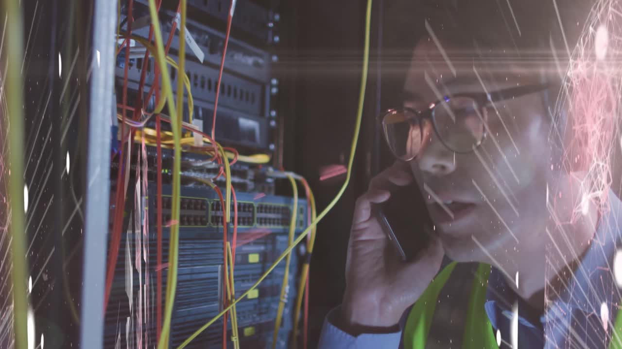 Animation of lights over asian man with smartphone working in server room