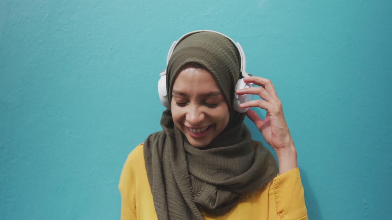 Woman wearing hijab with wireless headphone