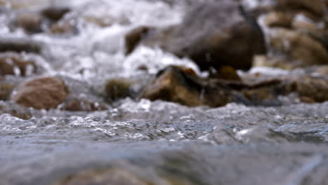 clear stream running through stone boulders abundant river flowing in slow motion