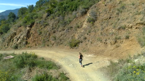 aerial footage of a blonde woman jogging down the mountain in marbella, spain