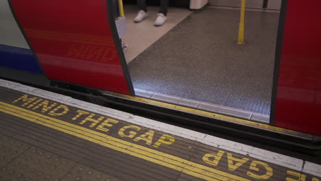 Mind-the-Gap-Sign-and-Opening-Doors-in-Metro-Underground-Subway-Station-Terminal-Close-Up-Slow-Motion