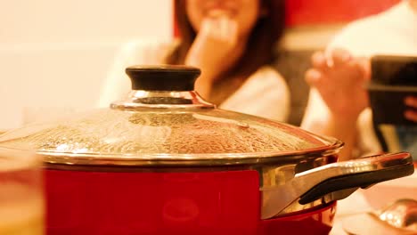 amigos disfrutando de una comida con una olla de sukiyaki