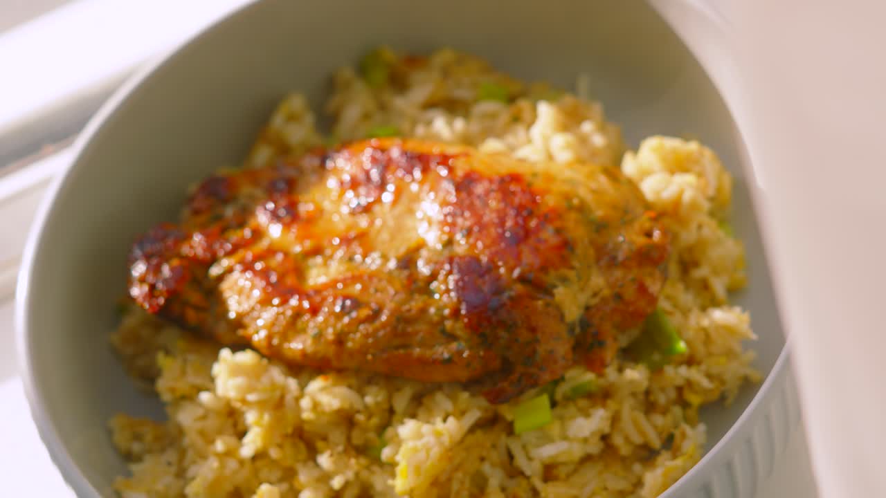 Overhead View of Freshly Cooked Delicious Chinese Chicken Steak Fillet Resting on Egg Fried Rice with Spring Onions in Natural Sunlight. Food Photography Footage 4K.