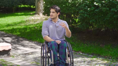 Slow-motion-of-young-disabled-man-sitting-in-wheelchair-and-angry.
