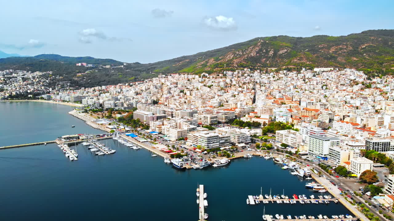 Aerial view of Kavala, a lot of buildings, Aegean sea coast, sea port, green hills in the distance, Greece