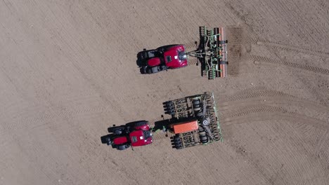 aerial zenithal shot of tractors lined up and ready on dry farmland near prague under sunlight