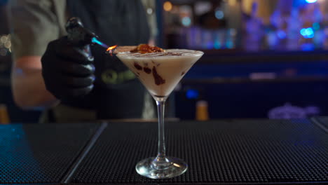 bartender smoking flaming cinnamon cocktail with torch