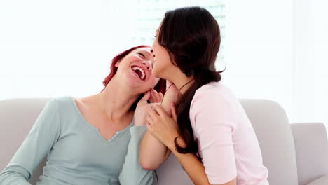 Amused-gorgeous-women-listening-with-headphones-to-music-while-sitting-on-couch