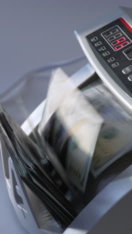 man puts a big wad of hundred dollar notes into money counting machine. side view. white background. vertical video