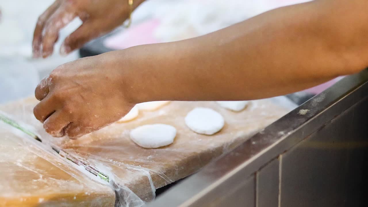 Hands shaping and cutting dough on a table