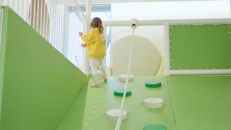 adorable toddler girl playing inside indoor playground