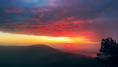 sun rising in the mountains with pink clouds and fog