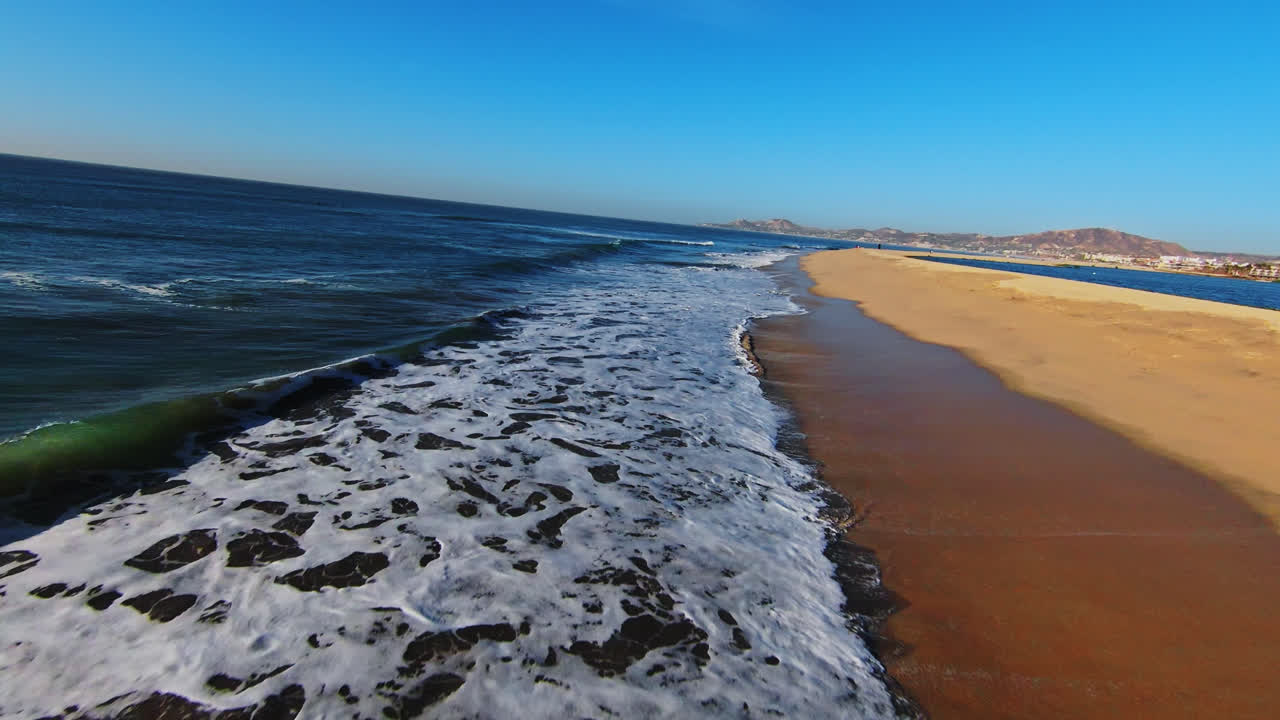 Zeegolven spatten op het zand op Isla San Jose in de Golf van Californië, Baja California, Mexico. FPV-drone.