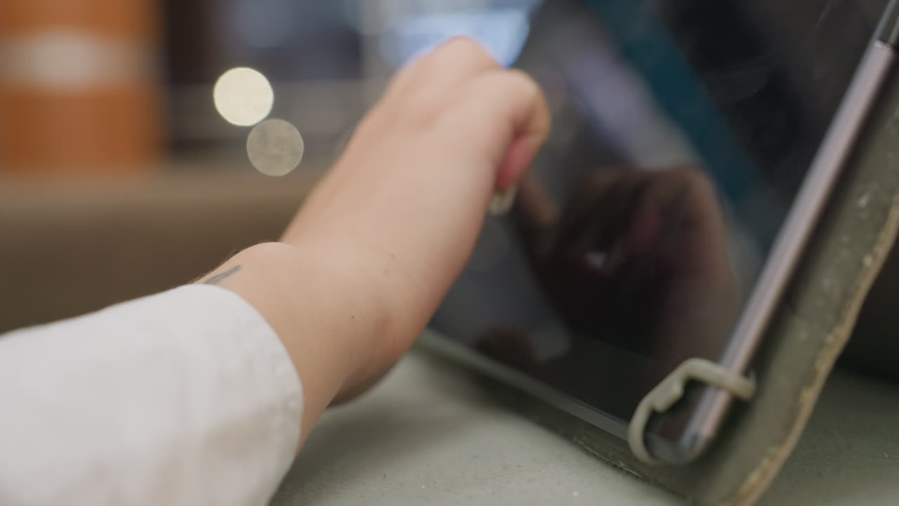 close up of woman hand interacting with tablet screen using finger gesture during casual moment in indoor setting with soft light and subtle background