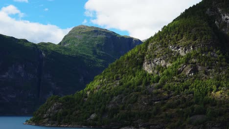 Paisaje-Masivo-Del-Fiordo-De-Geiranger,-Visto-Desde-Un-Crucero,-Grandes-Montañas-Saliendo-Del-Agua-Azul-En-4k