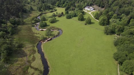 Drohnenaufnahme-Eines-Hauses-In-Den-Bergen-Mit-Einem-Fluss