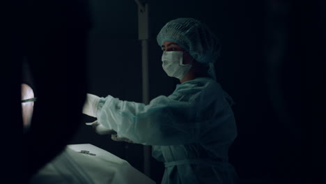 nurse handing surgical instruments helping doctor in hospital emergency ward.