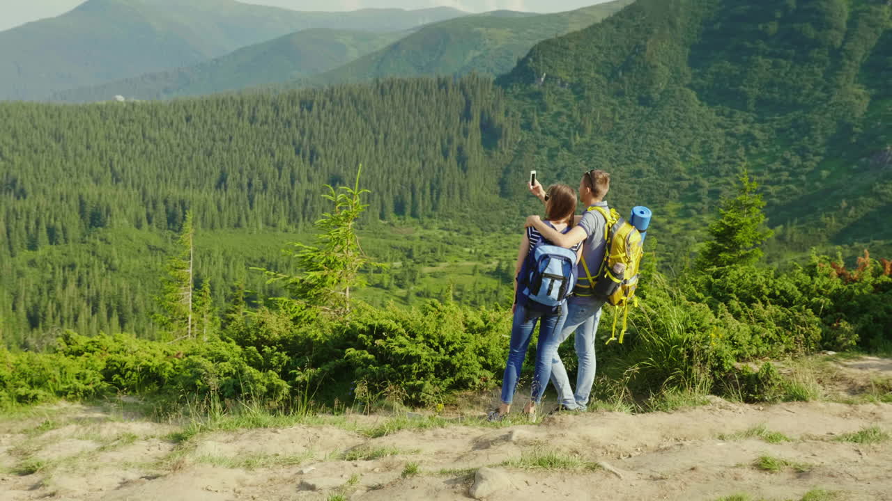 vacaciones en las montañas en verano un hombre toma fotos de su novia en un hermoso backgr