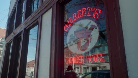 a charming street with historic building and vibrant neon sign of restaurant serving chowder in coastal city
