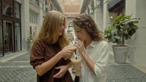 two friends enjoying bubble tea in a city street