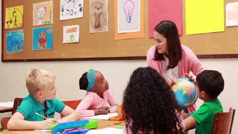 Teacher-and-pupils-looking-at-globe-