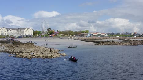 Galway-ireland-coast-and-salthill-promenade-fair-circus-at-ladies-beach,-currach-boats-in-water