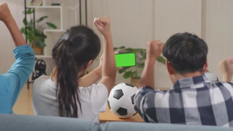 tiempo feliz de adolescentes asiáticos animando y viendo maquillaje de pantalla verde móvil y celebrando la victoria en casa, deportes y concepto de entretenimiento. vista trasera. amigos viendo deportes en el móvil
