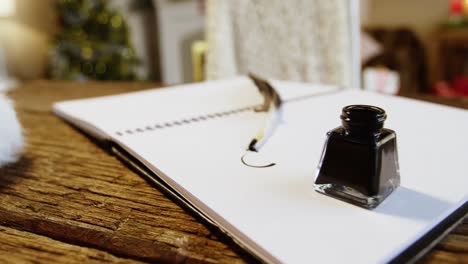 Close-up-of-diary-with-ink-bottle-and-quill