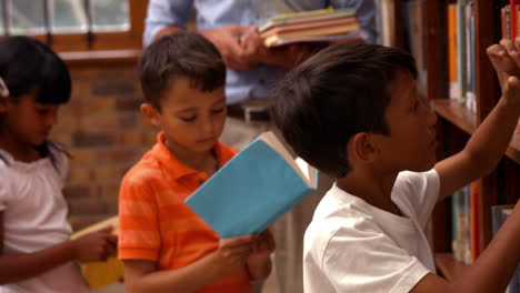 cute pupils with teacher in library