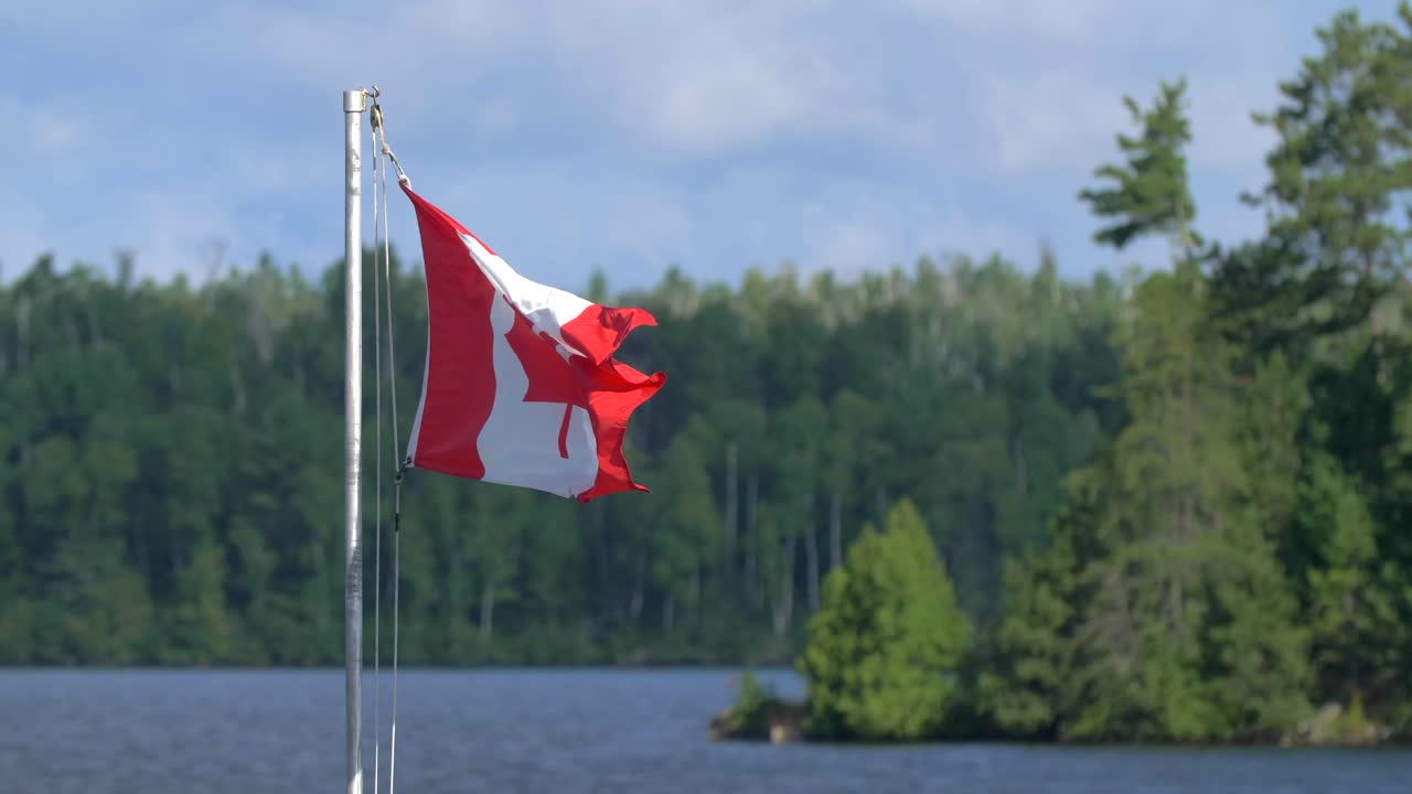 4k cámara lenta bandera de canadá tiro apretado aleteo en la brisa quetico desierto