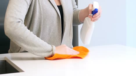 woman cleaning kitchen worktop