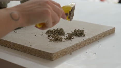 dropping bits of excess clay on table, in a charming studio