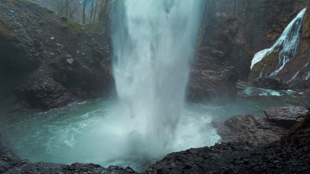 Powerful Berglist&uuml;ber waterfall in Switzerland seen from behind