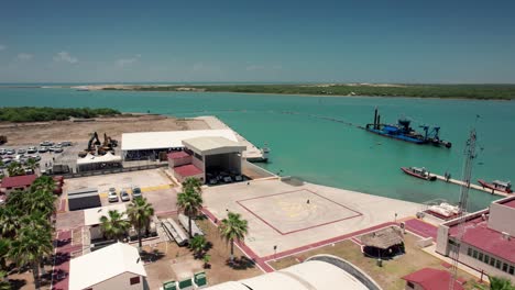 sand drainage plant overlooking the gulf of mexico in matamoros, with numerous birds flying in front of the image