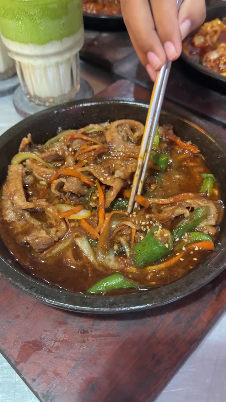 Person spiser koreansk bulgogi med spisepinde på en restaurant
