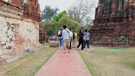 group of tourists walking around ancient temple ruins