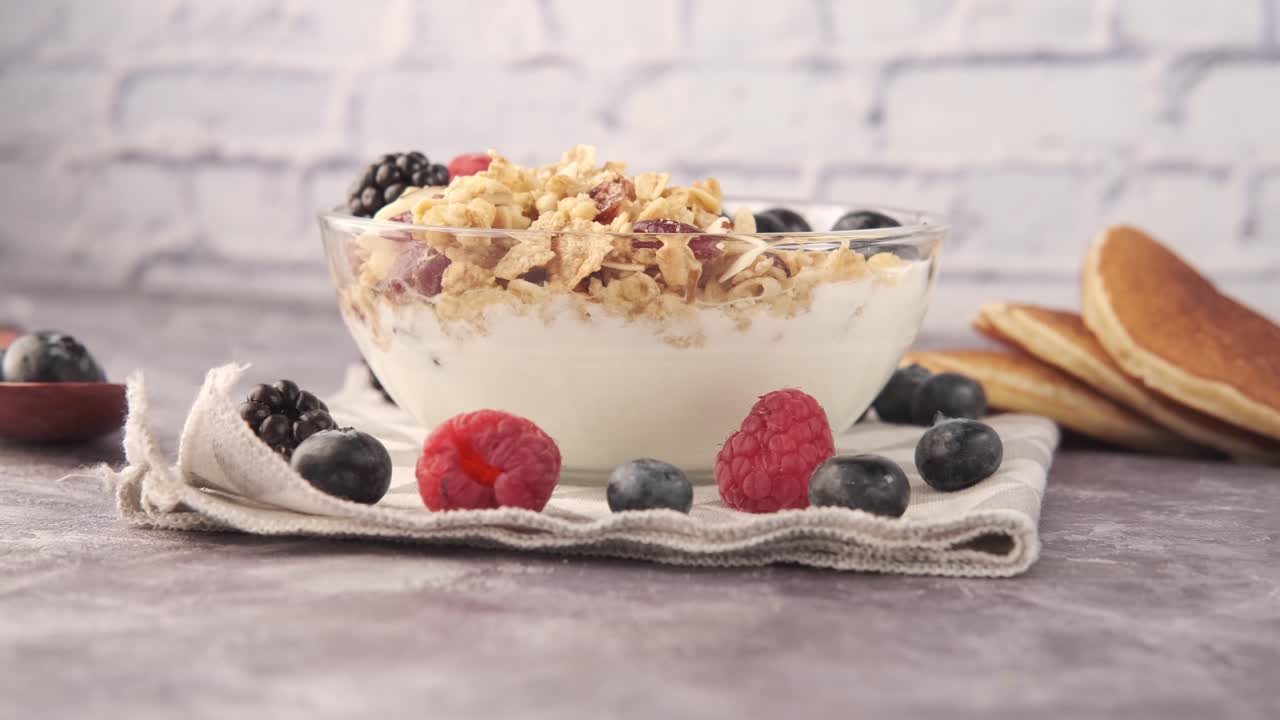 desayuno saludable con granola, yogur, bayas y panqueques